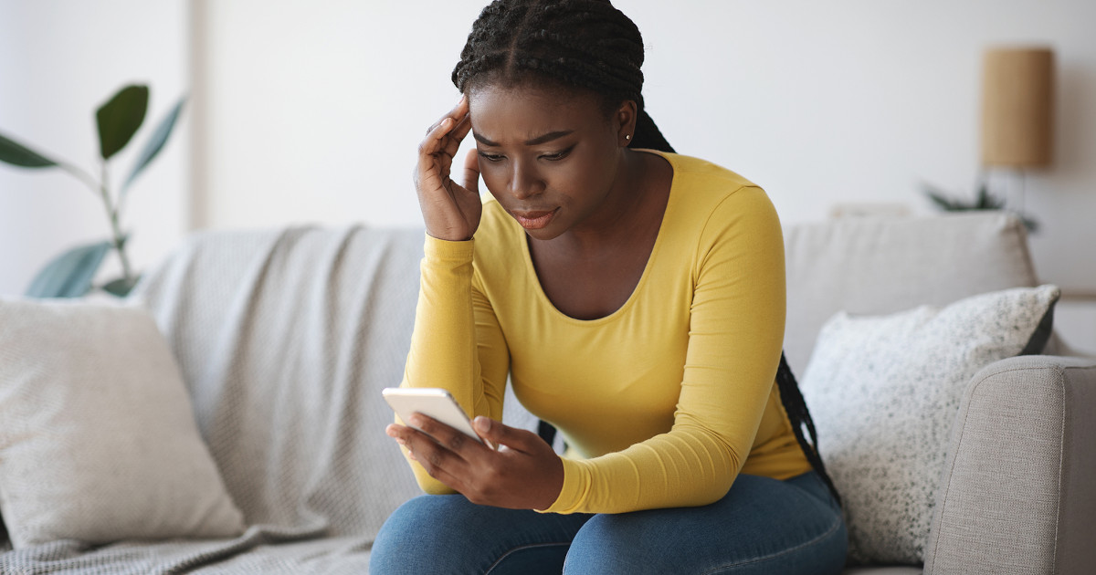 worried woman looking at her phone