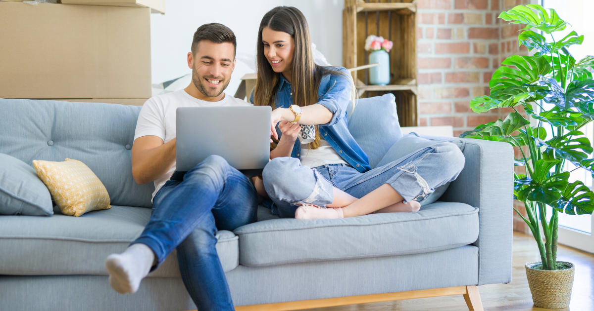 couple on sofa looking at laptop